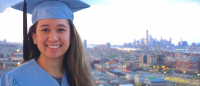 Woman smiling in front of cityscape.